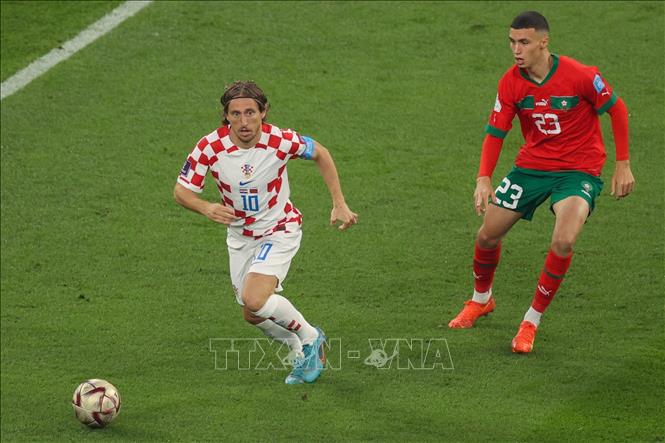 Luka Modric (trái) của Croatia đi bóng trước Bilal el Khannous của Maroc. Ảnh: AFP/TTXVN