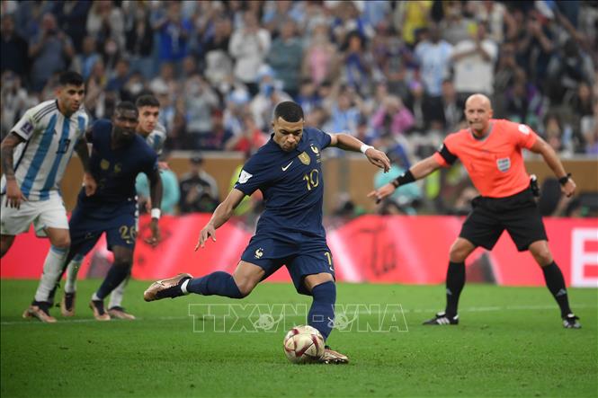 Phút 73, tiền đạo Randal Kolo Muani bị Acuna phạm lỗi trong vòng cấm. Mbappe (giữa) thực hiện cú sút phạt đền, đánh bại thủ thành Argentina Emi Martinez, rút ngắn cách biệt xuống 1-2 cho tuyển Pháp. AFP/TTXVN