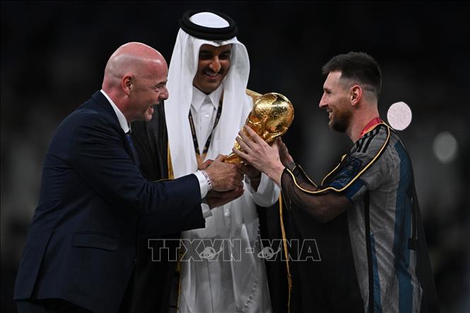 Giây phút cầu thủ vĩ đại nhất trong lịch sử Lionel Messi (phải) nhận Cup vô địch World Cup 2022 cho tuyển Argentina từ Chủ tịch FIFA Gianni Infantino (trái). Ảnh: AFP/TTXVN