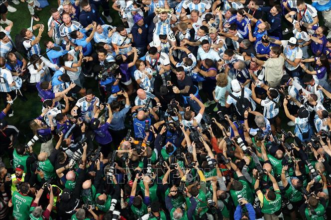 Các tuyển thủ Argentina rước Cúp vô địch chia vui cùng cổ động viên trên sân Lusail, Qatar. Ảnh: AFP/TTXVN