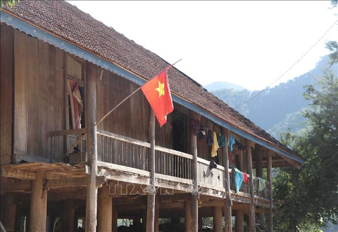 Trong ảnh: Cờ Tổ quốc được người dân bản Nậm Hẹ 1 (xã Hẹ Muông, huyện Điện Biên, tỉnh Điện Biên) cắm bên hiên trên những ngôi nhà sàn truyền thống. Ảnh: Xuân Tiến – TTXVN 