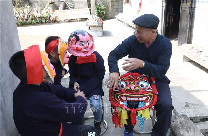 Bậc cao niên trong đội múa sư tử thôn Cốc Lào, xã Hội Hoan giảng giải cho thành viên nhí của đội về nguồn gốc múa sư tử. Ảnh: Anh Tuấn – TTXVN