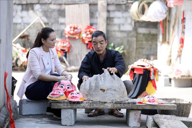 Nghệ nhân làm đầu sư tử Hoàng Thanh Huy, thôn Bản Kìa, xã Hội Hoan, huyện Văn Lãng, tỉnh Lạng Sơn giới thiệu về cách làm đầu sư tử độc đáo của mình được nhiều địa phương đặt hàng. Ảnh: Anh Tuấn – TTXVN