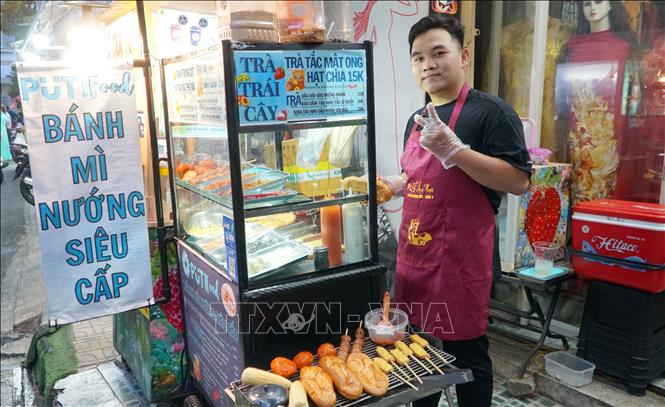 Các tiểu thương với chiếc tạp dề có in dòng chữ 