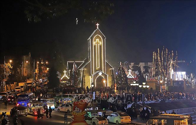 Người dân thị xã Sa Pa (Lào Cai) cùng đông đảo khách du lịch đón Giáng sinh tại Nhà thờ đá. Ảnh: Quốc Khánh - TTXVN
