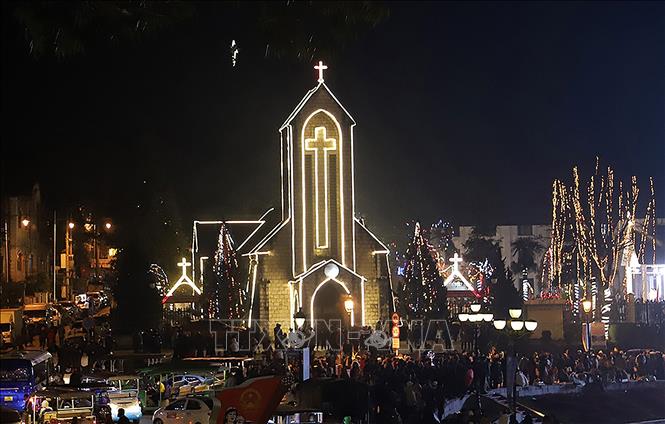 Người dân thị xã Sa Pa (Lào Cai) cùng đông đảo khách du lịch đón Giáng sinh tại Nhà thờ đá. Ảnh: Quốc Khánh - TTXVN