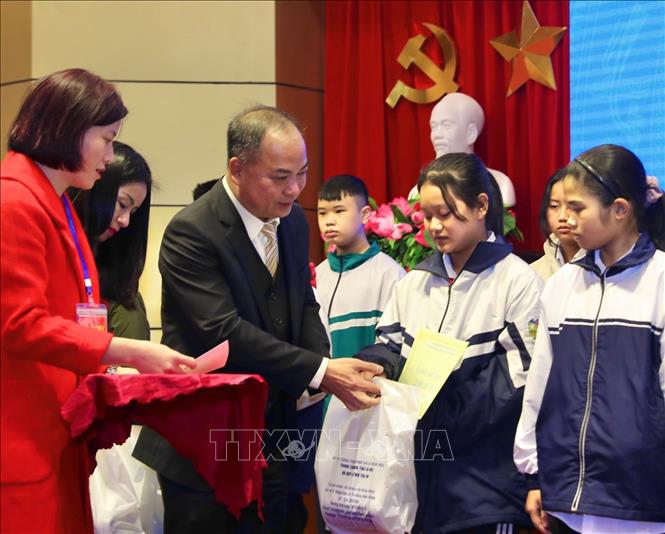 Giám đốc Quỹ bảo trợ trẻ em Việt Nam Đinh Tiến Hải trao quà và học bổng cho trẻ em có hoàn cảnh đặc biệt, hoàn cảnh khó khăn. Ảnh: Hoàng Hiếu - TTXVN
