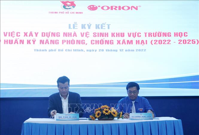 Ông Park Se Yeol - Tổng Giám đốc Công ty TNHH Thực phẩm Orion Vina và ông Dương Ngọc Tuấn - Giám đốc Trung tâm Công tác xã hội Thanh niên Thành phố Hồ Chí Minh thực hiện ký kết. Ảnh: Thu Hương - TTXVN