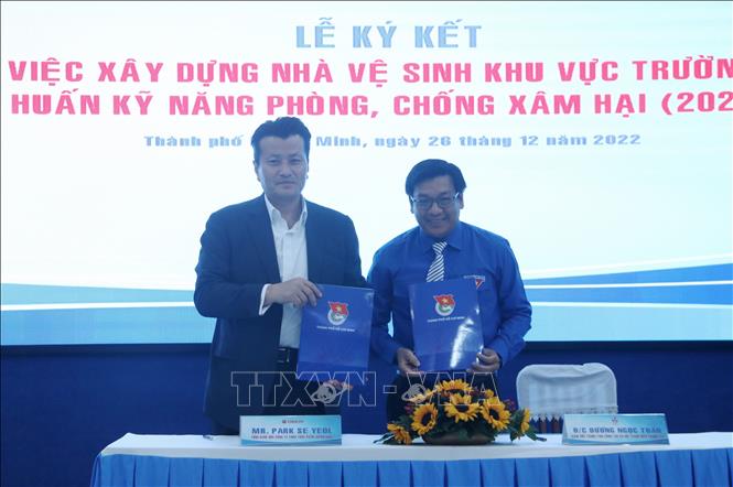 Ông Park Se Yeol - Tổng Giám đốc Công ty TNHH Thực phẩm Orion Vina và ông Dương Ngọc Tuấn - Giám đốc Trung tâm Công tác xã hội Thanh niên Thành phố Hồ Chí Minh thực hiện ký kết. Ảnh: Thu Hương - TTXVN