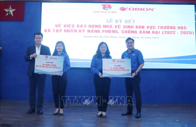 Ông Ngô Minh Hải - Phó Bí thư thường trực Thành đoàn Thành phố Hồ Chí Minh và ông Park Se Yeol - Tổng Giám đốc Công ty TNHH Thực phẩm Orion Vina trao bảng tượng trưng tài trợ cho huyện Đoàn Củ Chi và Bình Chánh. Ảnh: Thu Hương - TTXVN