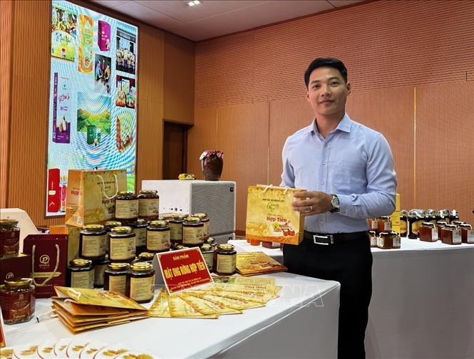 Trong ảnh: Giám đốc Hợp tác xã Green Life Đinh Công Thuần cùng sản phẩm mật ong Hợp Tiến tại buổi trưng bày, đánh giá sản phẩm OCOP tỉnh Hòa Bình năm 2022. Ảnh: Vũ Hà- TTXVN