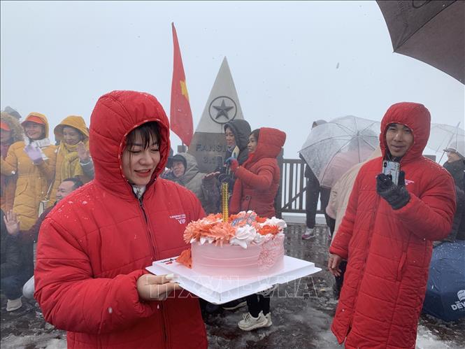 A tourist celebrates her birthday on snowy Mount Fansipan. VNA Photo: Quốc Khánh 