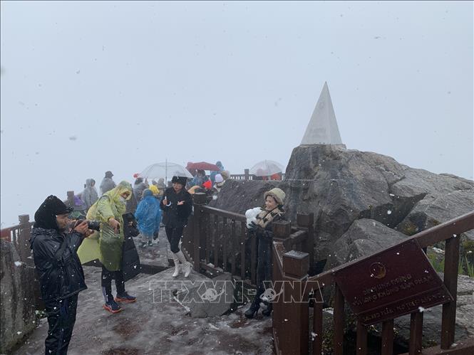 Tourists flock to Sa Pa to experience snowfall on Mount Fansipan. VNA Photo: Quốc Khánh 