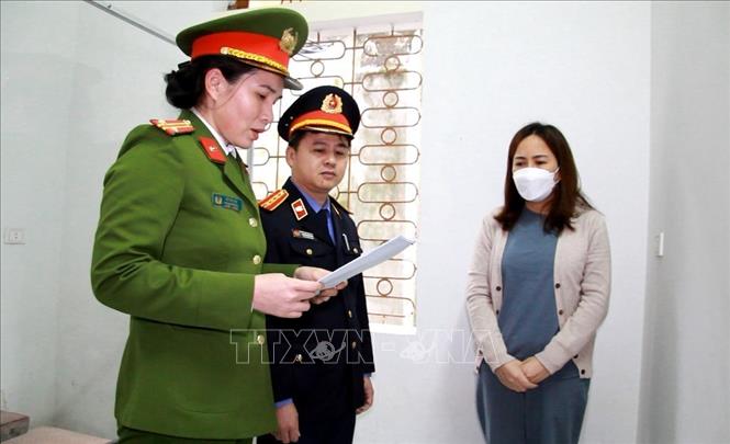 Trong ảnh: Cơ quan chức năng tiến hành tống đạt quyết định khởi tố, bắt tạm giam đối với bị can Đinh Thị Hòa (phải), Phó Giám đốc Công ty Trách nhiệm hữu hạn Lao Base Barite, về hành vi “Đưa hối lộ”. Ảnh: TTXVN phát