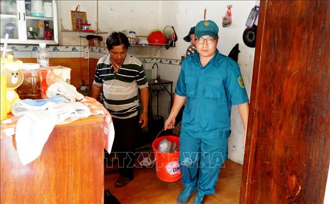 Hỗ trợ người dân di dời đồ đạc ra khỏi khu vực sạt lở. Ảnh: Lê Thúy Hằng - TTXVN