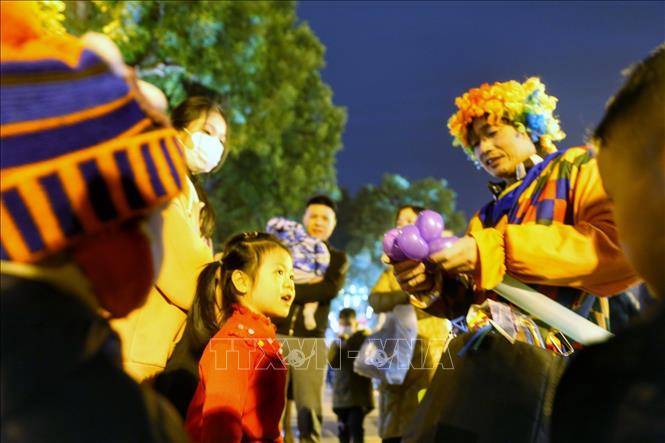 Các em nhỏ chờ chú hề làm những quả bóng cho mình. Ảnh: Tuấn Đức - TTXVN