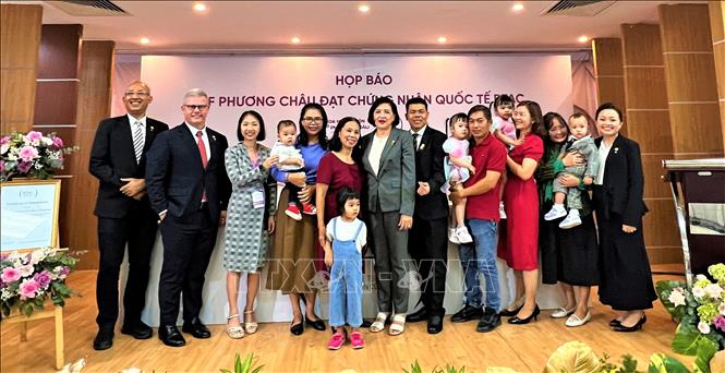 Couples having their babies through IVF and the Phuong Chau Group's management board pose for a group photo at the press conference. VNA Photo: Ánh Tuyết