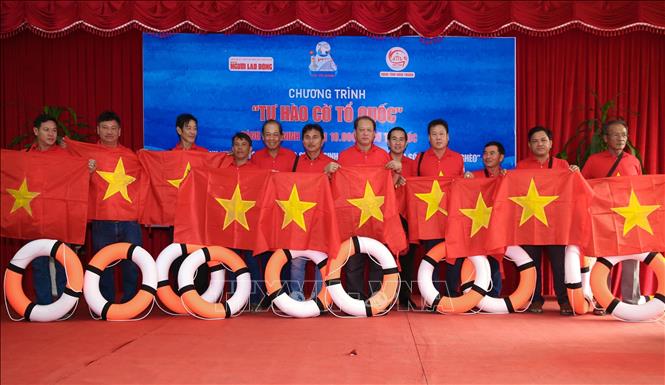 Nguoi Lao Dong (Labourer) Newspaper presents national flag to fishermen in Ninh Thuan province. VNA Photo: Công Thử