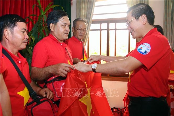 Standing Deputy Secretary of Ninh Thuan Provincial Party Committee Pham Van Hau presents national flags to fishermen. VNA Photo: Công Thử