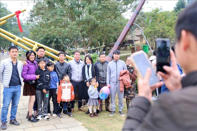 Du khách chụp ảnh lưu niệm tại phiên chợ. Ảnh: Tuấn Đức - TTXVN