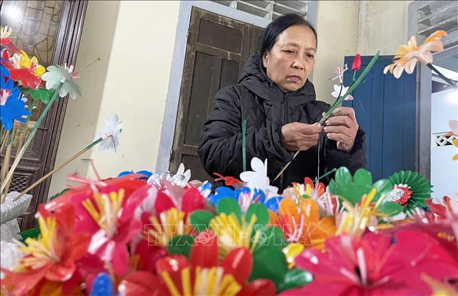 Trong ảnh: Các công đoạn để làm nên hoa giấy Thanh Tiên khá công phu và cầu kỳ. Sau khi cắt, dán tạo nên những loài hoa đẹp, nghệ nhân sẽ đính kết các loài hoa này tạo thành những cành hoa đầy màu sắc. Ảnh: Mai Trang - TTXVN