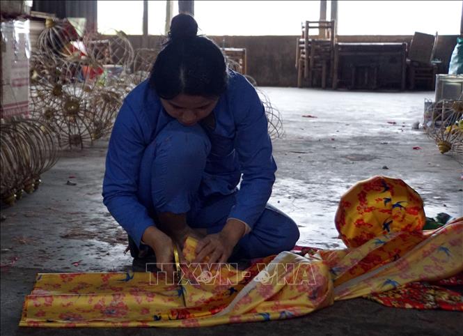 Các nghệ nhân thực hiện các công đoạn trong sản xuất đèn lồng ở thành phố Hội An. Ảnh: Trịnh Bang Nhiệm - TTXVN