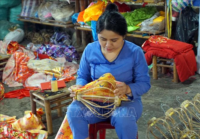 Các nghệ nhân thực hiện các công đoạn trong sản xuất đèn lồng ở thành phố Hội An. Ảnh: Trịnh Bang Nhiệm - TTXVN
