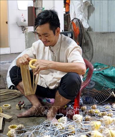 Các nghệ nhân thực hiện các công đoạn trong sản xuất đèn lồng ở thành phố Hội An. Ảnh: Trịnh Bang Nhiệm - TTXVN