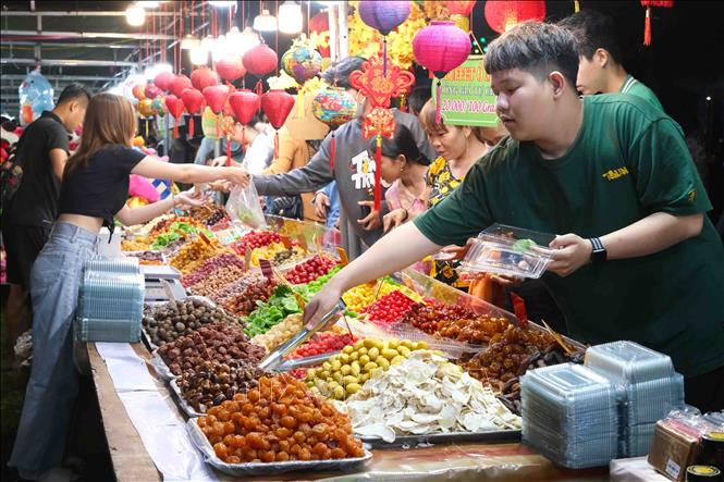Người dân quận Thốt Nốt mua sắm tại hội chợ được tổ chức cùng Tết quân dân. Ảnh: Thanh Liêm - TTXVN