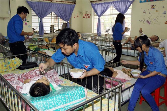 Đoàn viên thanh niên TP. Hồ Chí Minh chăm sóc trẻ khuyết tật tại Trung tâm Bảo trợ trẻ em tàn tật Thị Nghè. Ảnh: Thanh Vũ – TTXVN