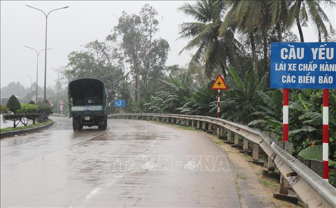 Cơ quan chức năng cắm bảng cảnh báo cầu yếu phía đầu cầu Trà Khúc. Ảnh: Phạm Cường-TTXVN
