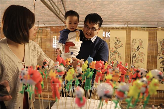 Tại không gian bích họa trên phố Phùng Hưng giới thiệu các sản phẩm dân gian truyền thống của nghệ nhân, thợ thủ công làng nghề Việt Nam như tranh dân gian, thư pháp, gốm sứ, mây tre đan, đồ chơi tò he… Ảnh: Minh Quyết - TTXVN