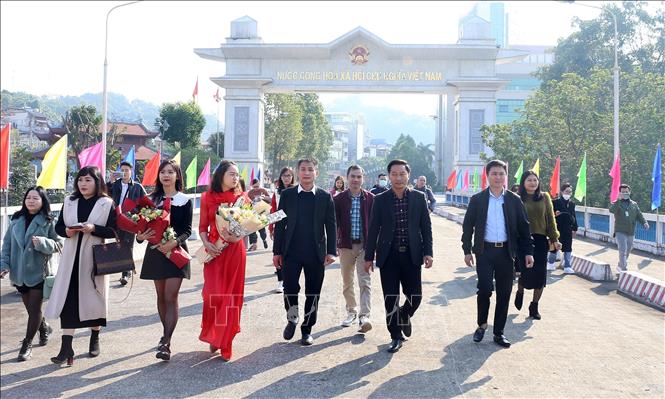 At the event, the organising board presented flowers to 30 tourists and residents from Hekou. VNA Photo: Quốc Khánh