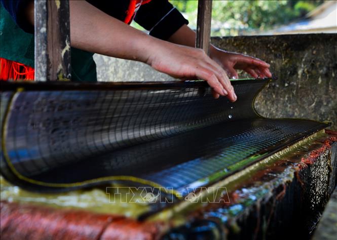 Trong ảnh: Những lớp giấy được sau khi được tráng sẽ được vuốt xếp phẳng phiu theo từng xấp. Ảnh: Nam Thái - TTXVN