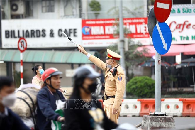 Lực lượng CSGT phân luồng, hướng dẫn các phương tiện trong ngày đầu tổ chức lại giao thông. Ảnh: Huy Hùng - TTXVN