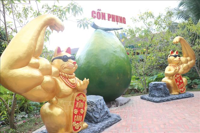 Trong ảnh: Khách du lịch thích thú chụp ảnh với linh vật “Mèo lực sĩ” . Ảnh: Huỳnh Phúc Hậu - TTXVN