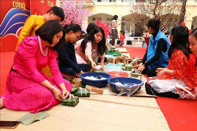 Thầy cô giáo và các học sinh nhà trường tham gia gói bánh chưng. Ảnh: Huy Hùng - TTXVN