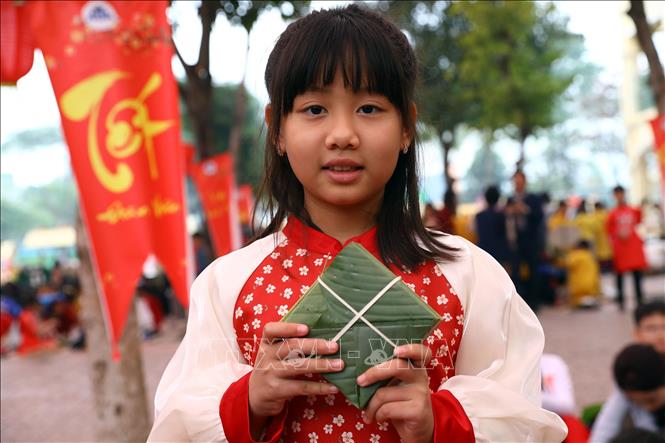 Niềm vui của em học sinh sau khi tự tay gói được chiếc bánh chưng. Ảnh: Huy Hùng - TTXVN