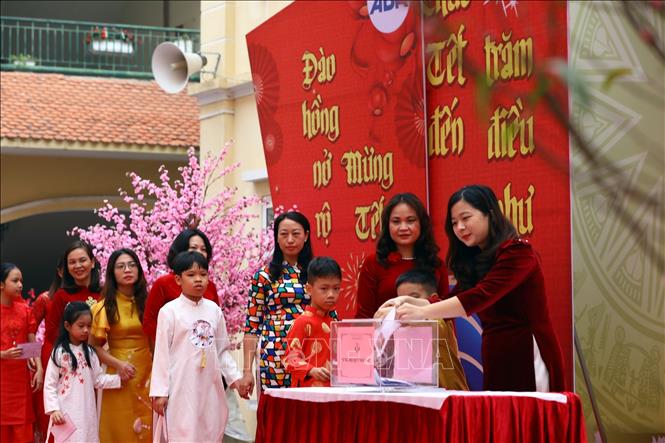 Học sinh và giáo viên nhà trường ủng hộ cho quỹ nhân ái để giúp đỡ các bạn có hoàn cảnh khó khăn. Ảnh: Huy Hùng - TTXVN