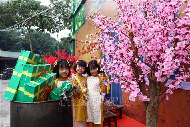 Các học sinh với góc Tết cổ truyền được trưng bày tại khuôn viên trường học. Ảnh: Huy Hùng - TTXVN