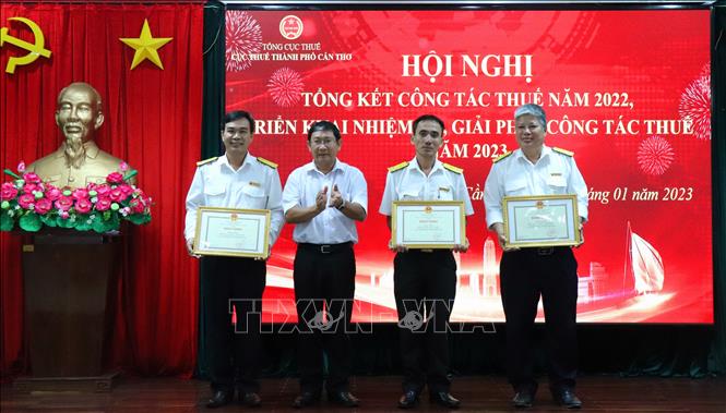 Ông Nguyễn Quang Nghị, Giám đốc Sở Tài chính Cần Thơ trao tặng bằng khen của Chủ tịch UBND thành phố cho 3 tập thể thu thuế đạt và vượt dự toán được giao. Ảnh: Thu Hiền - TTXVN