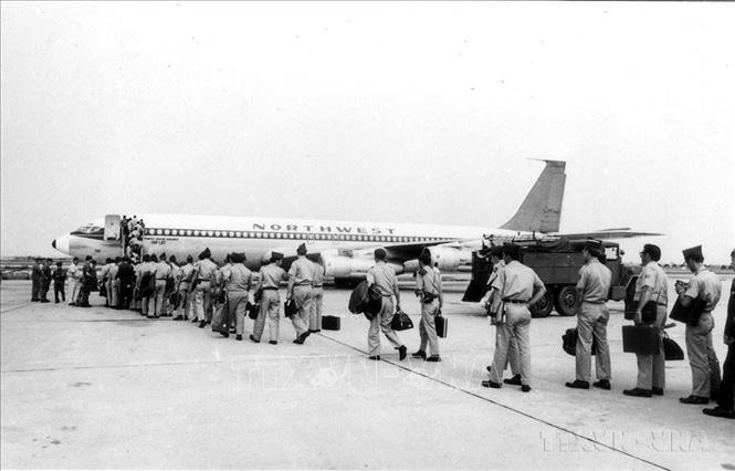 Thực thi Hiệp định Paris, lính Mỹ lên máy bay rút khỏi miền Nam Việt Nam dưới sự giám sát của Quân đội Việt Nam Dân chủ Cộng hoà và quân Giải phóng, tại sân bay Tân Sơn Nhất, ngày 19/3/1973. Ảnh: Hứa Kiểm – TTXVN