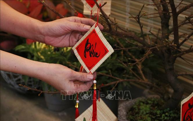 Trong ảnh: Những phụ kiện trang trí Tết được người dân lựa chọn tỉ mỉ. Ảnh: Thu Hương - TTXVN