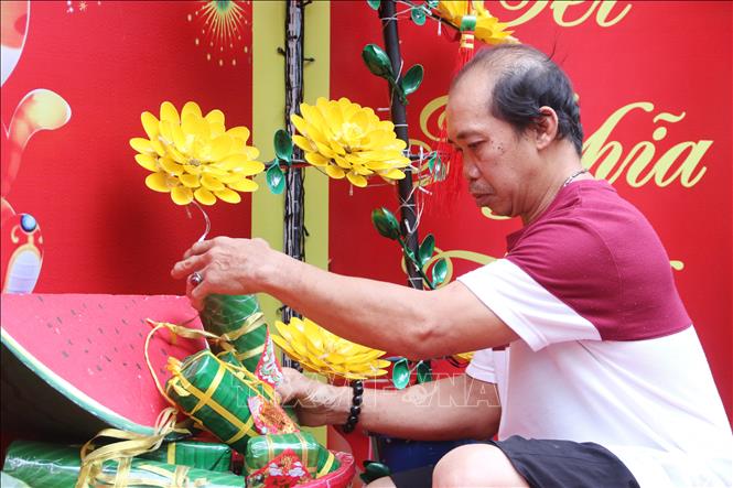 Trong ảnh: Người dân tại hẻm 153 Nguyễn Thị Minh Khai (Quận 1) lựa chọn những tiểu cảnh để trưng bày tại đường hoa mini. Ảnh: Thu Hương - TTXVN