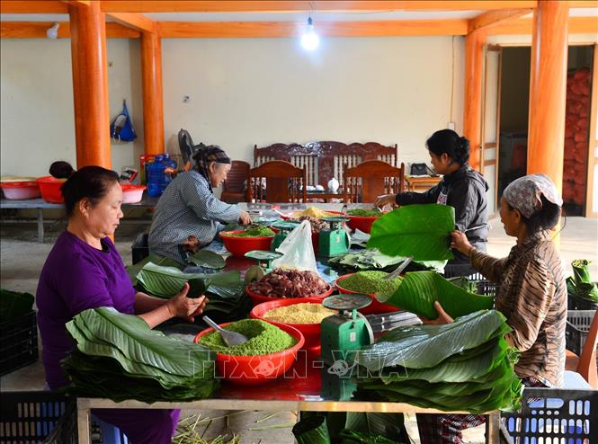 Trong ảnh: Chủ yếu những người phụ nữ sẽ đảm nhiệm công việc gói bánh. Ảnh: Nam Thái - TTXVN