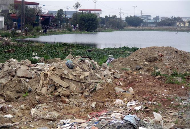 Rác thải xây dựng vứt ngổn ngang quanh khu vực hồ nước tự nhiên thuộc địa bàn phường Hải Bình, thị xã Nghi Sơn, Thanh Hóa. Ảnh: Nguyễn Nam-TTXVN