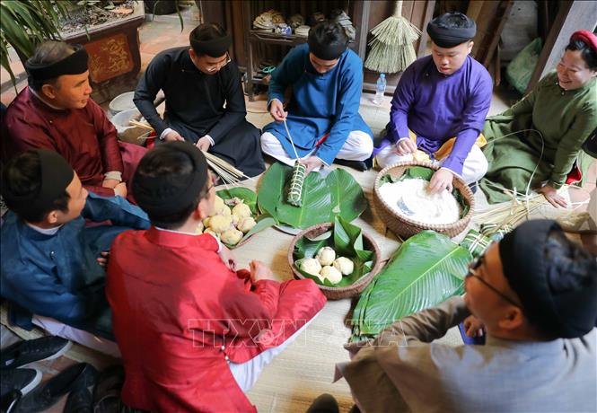 Khoảng thời gian gói bánh cũng là lúc mọi người cùng nhau ôn lại chuyện cũ trong năm. Ảnh: Thanh Tùng - TTXVN
