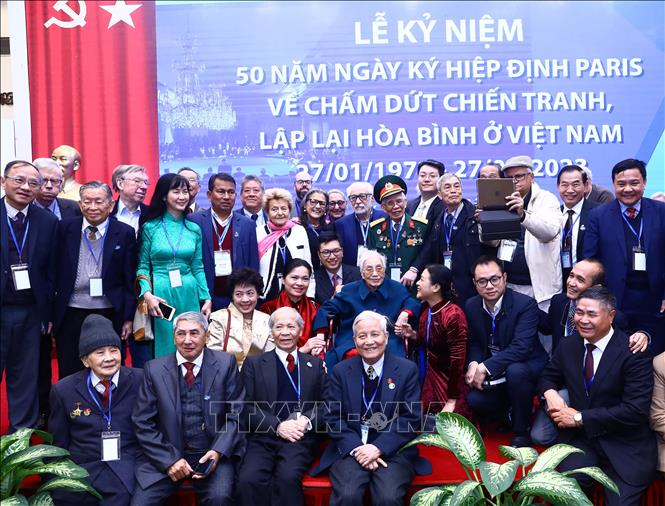 Former Vice President and former Foreign Minister Nguyen Thi Binh, who was head of the negotiation delegation of the Provisional Revolutionary Government of the Republic of South Vietnam at the Paris Conference, poses for a group photo with delegates the meeting. VNA Photo: Lâm Khánh
