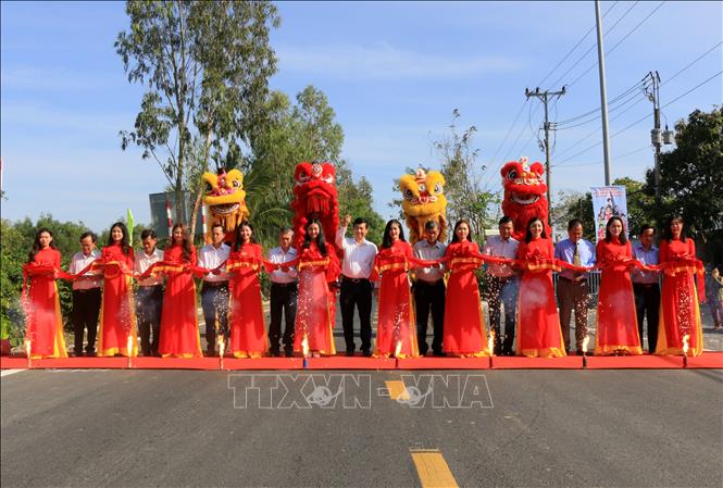 Đại biểu thực hiện nghi thức cắt băng khánh thành dự án mở rộng tỉnh lộ 849 đoạn từ ĐT.848 đến Quốc lộ 80. Ảnh: Nhựt An - TTXVN