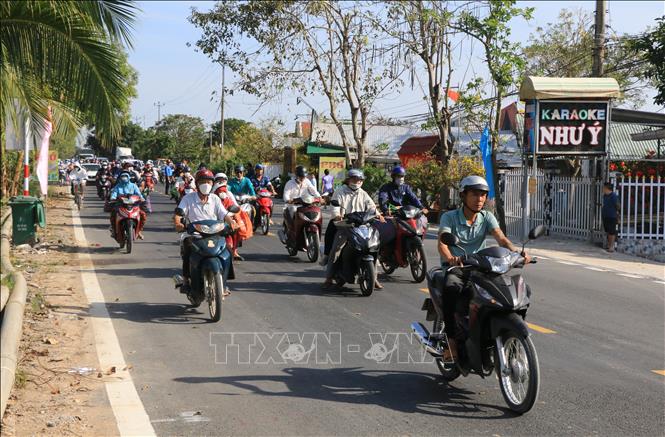 Người dân phấn khởi lưu thông trên đoạn tỉnh lộ 849 vừa được nâng cấp, mở rộng. Ảnh: Nhựt An - TTXVN